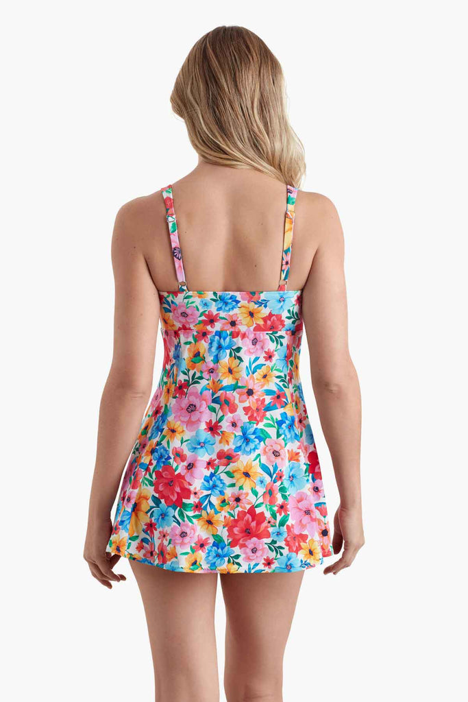 Woman facing away wearing a swim dress with a multicolored floral print