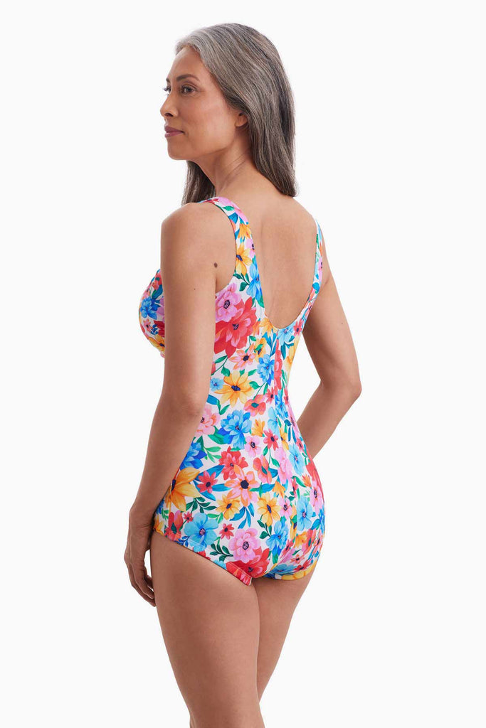 Woman turned left wearing a one-piece swimsuit with a multicolored floral print