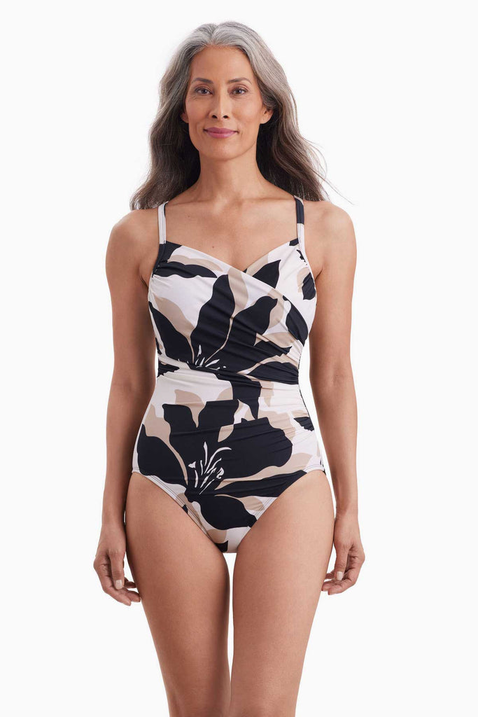 Woman wearing a one-piece swimsuit with a large black and white floral pattern