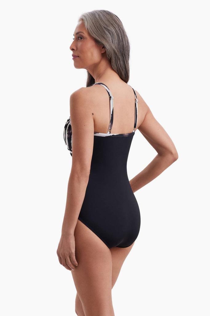 Woman turned left to show detail of  one-piece swimsuit 