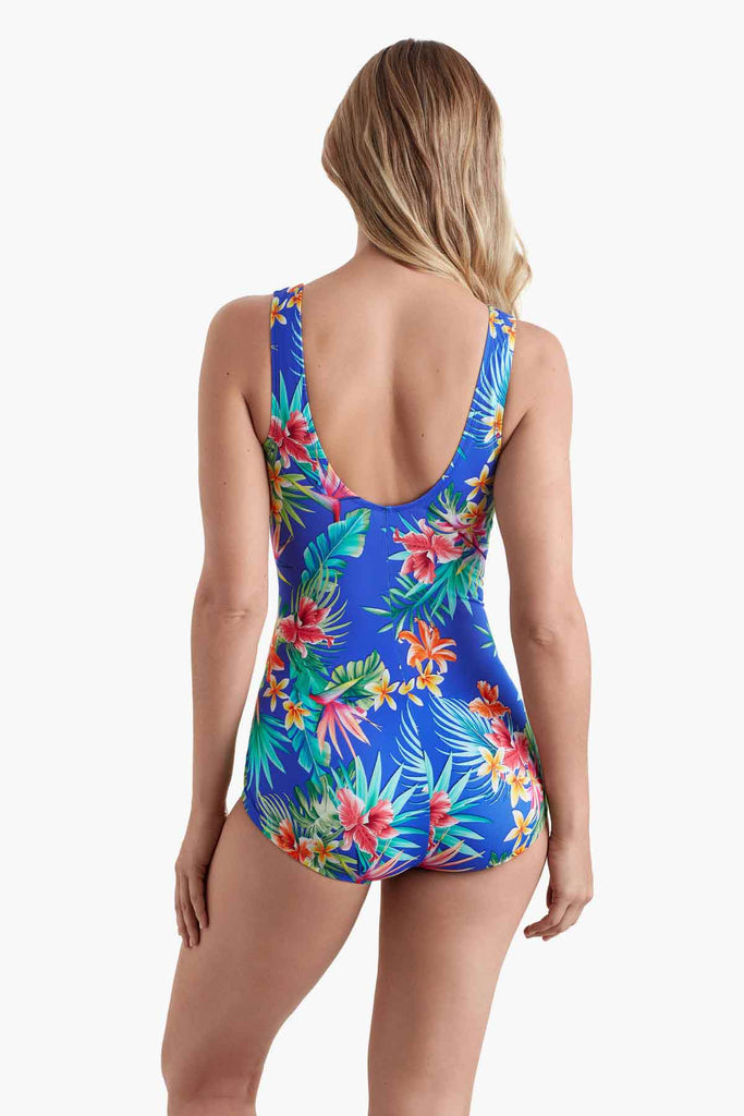 Woman turned away wearing a one-piece swimsuit with a multicolored floral pattern