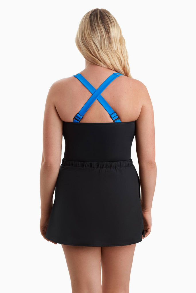 Woman turned away wearing a one-piece swimsuit with blue X back straps