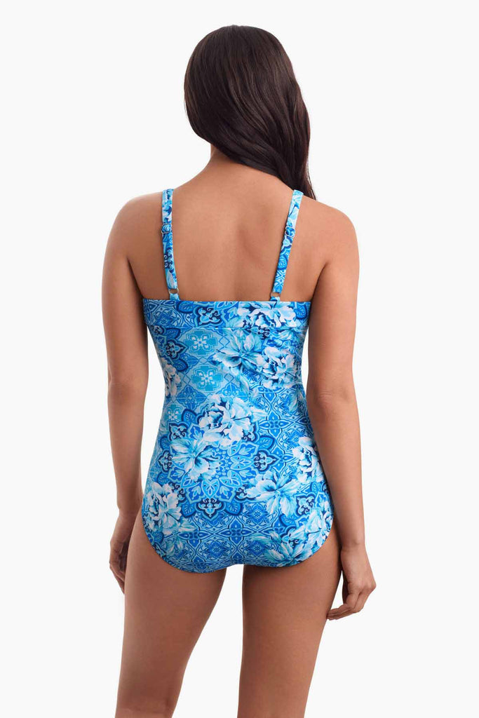 Woman faced away to show back of blue abstract printed one-piece 