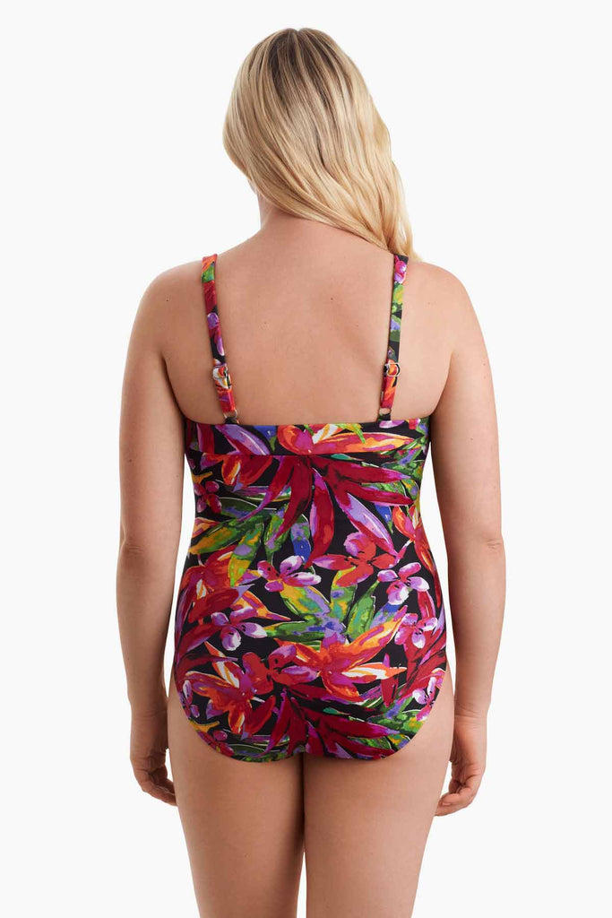 Woman faced away wearing a multicolored one-piece swimsuit with a floral print