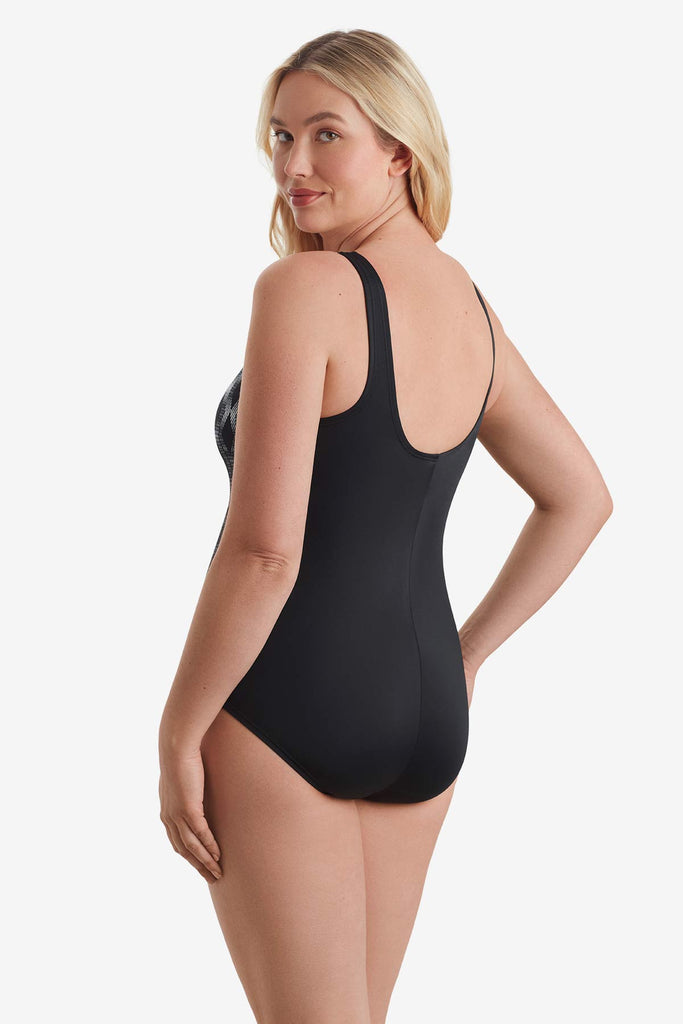 Woman turned to the left to show detail of one-piece swimsuit