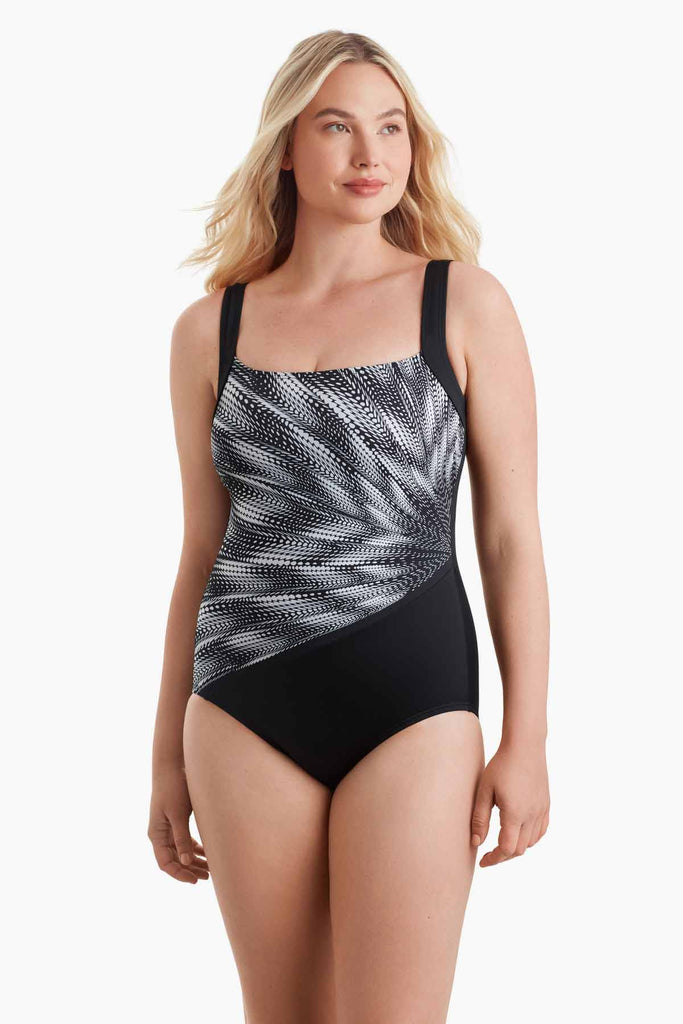 Woman wearing a one-piece swimsuit with a black and white pattern