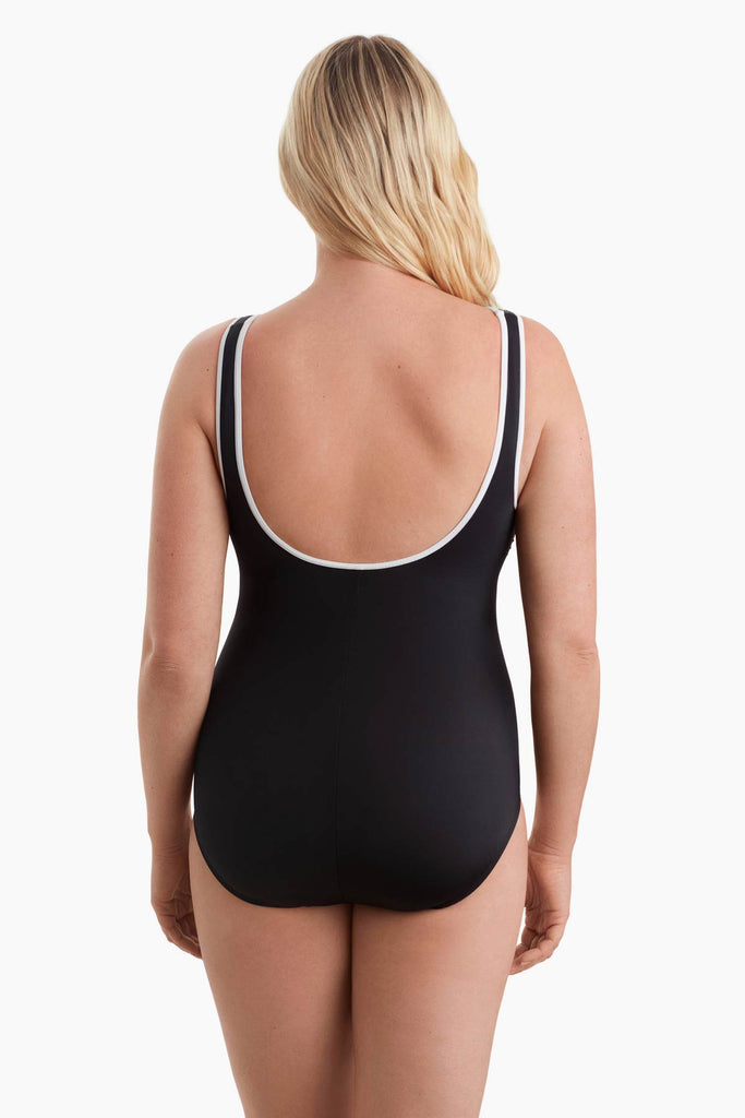 Woman turned away to show white trim detail of the one-piece swimsuit