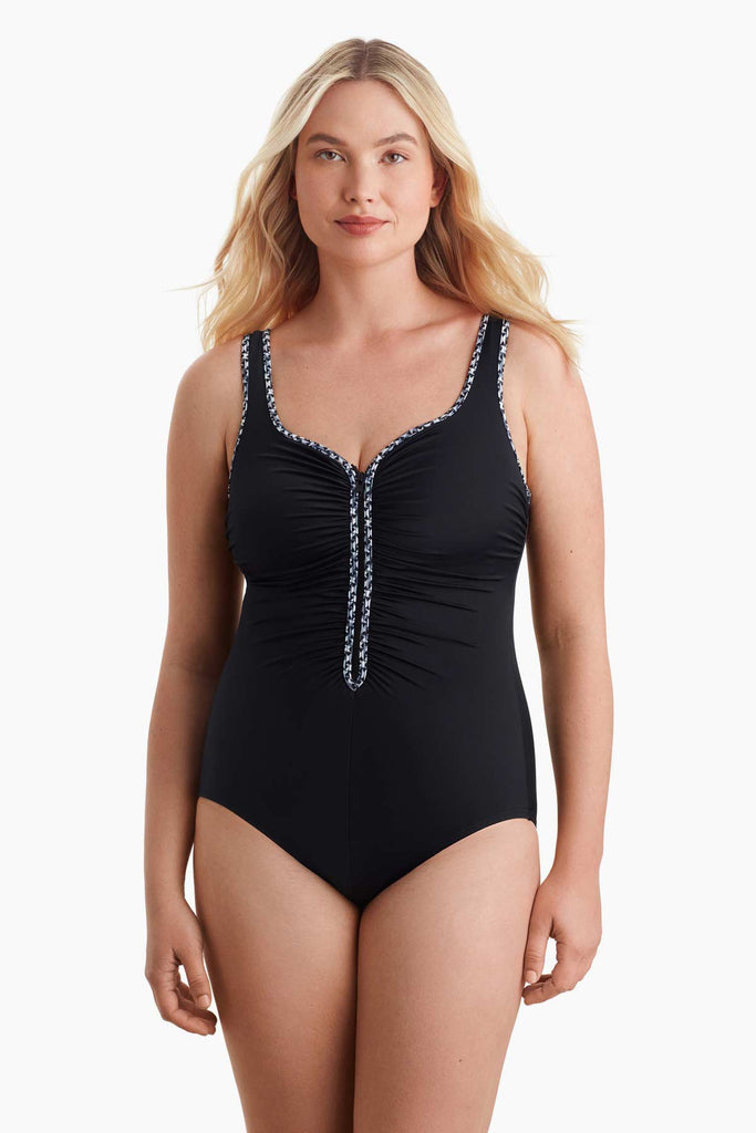 Woman wearing a one-piece swimsuit with black and white trim on the front