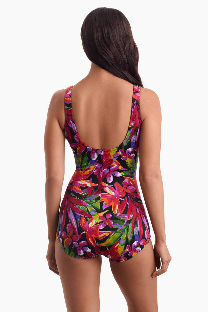 Woman facing away wearing a multicolored swimsuit with a floral print