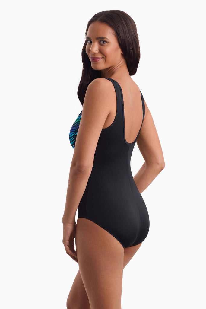 Woman facing left to show off the side detail of one-piece swimsuit