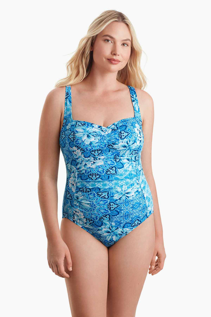 Woman wearing an abstract printed blue one-piece swimsuit