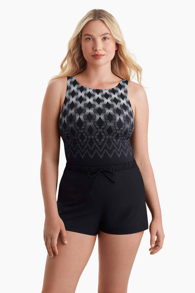 Woman wearing a one-piece swimsuit with a geometric pattern