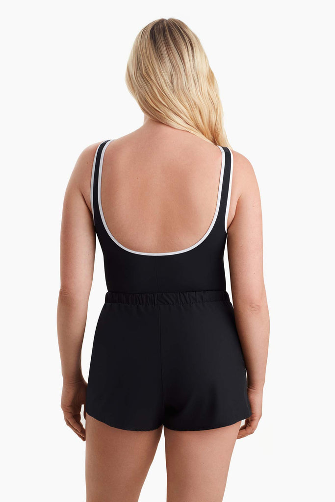 Woman faced away to show white trim on the back of the one-piece swimsuit