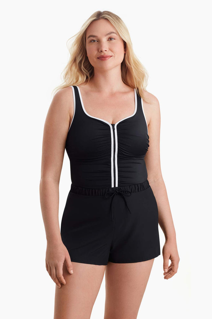 Woman wearing a one-piece swimsuit with white trim on the front