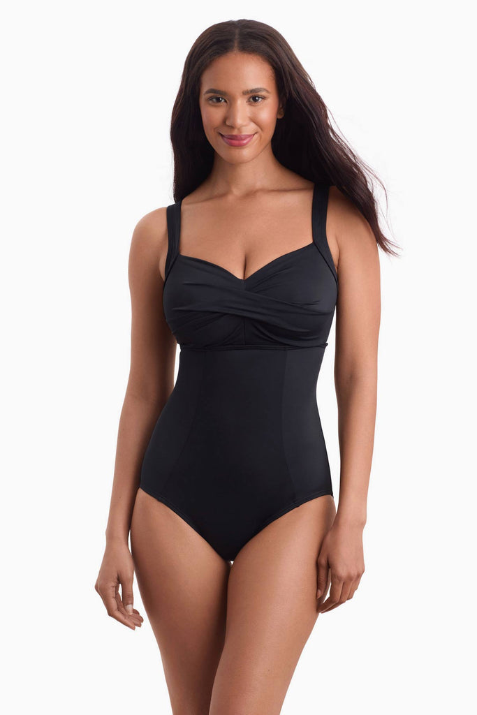 Woman wearing a black one-piece swimsuit with a sweetheart neckline