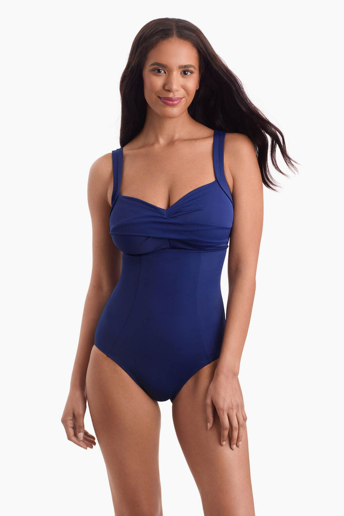 Woman wearing a navy blue one-piece swimsuit with a sweetheart neckline