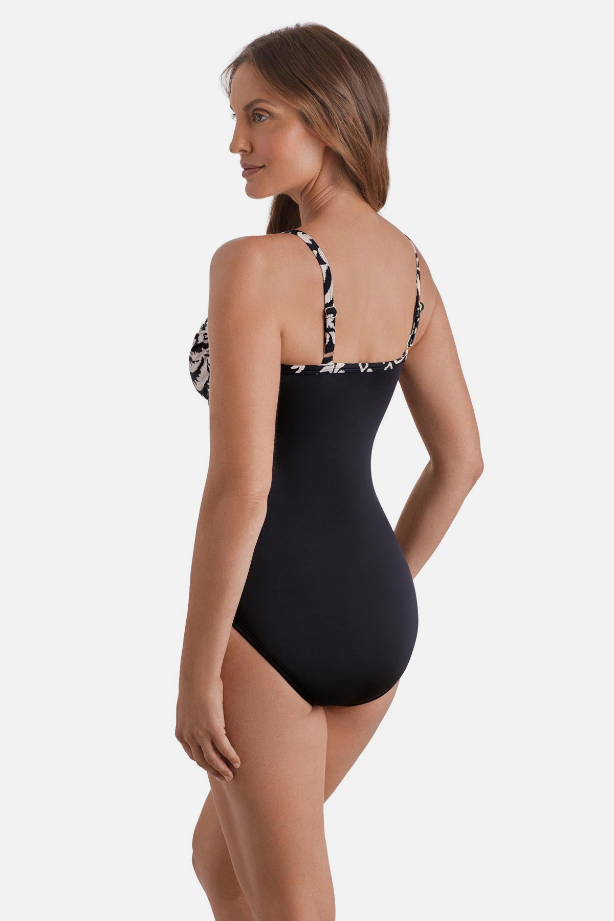 Woman turned left wearing a black and white palm tree printed one-piece swimsuit